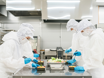 食品工場で働く作業員たちの写真